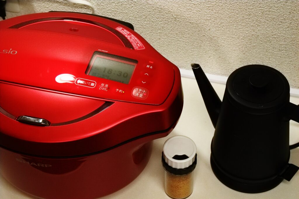 一个红色的瓦罐放在柜台上，旁边是一个黑色的茶壶