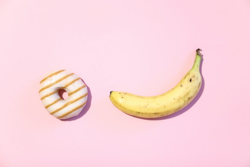 粉色背景上的香蕉和甜甜圈