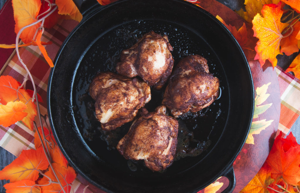 鸡腿在铸铁煎锅与秋季装饰